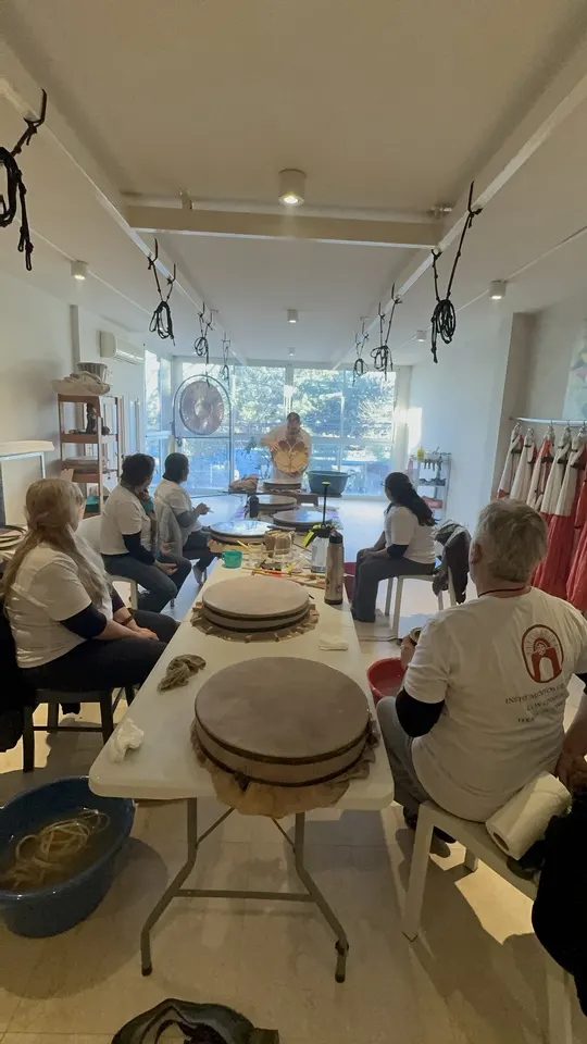 El taller de Bernal durante la formación: mesas con tambores en construcción, alumnos y Ra al fondo junto al gong